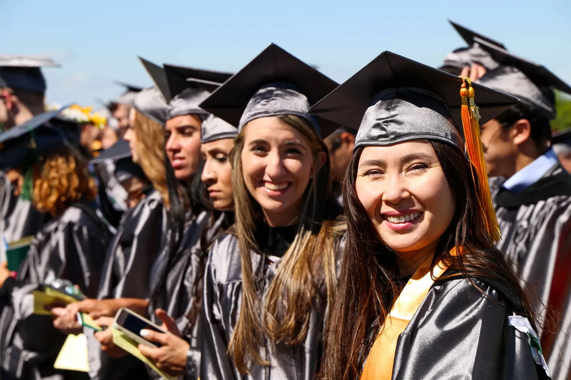 Women smiling at graduation.