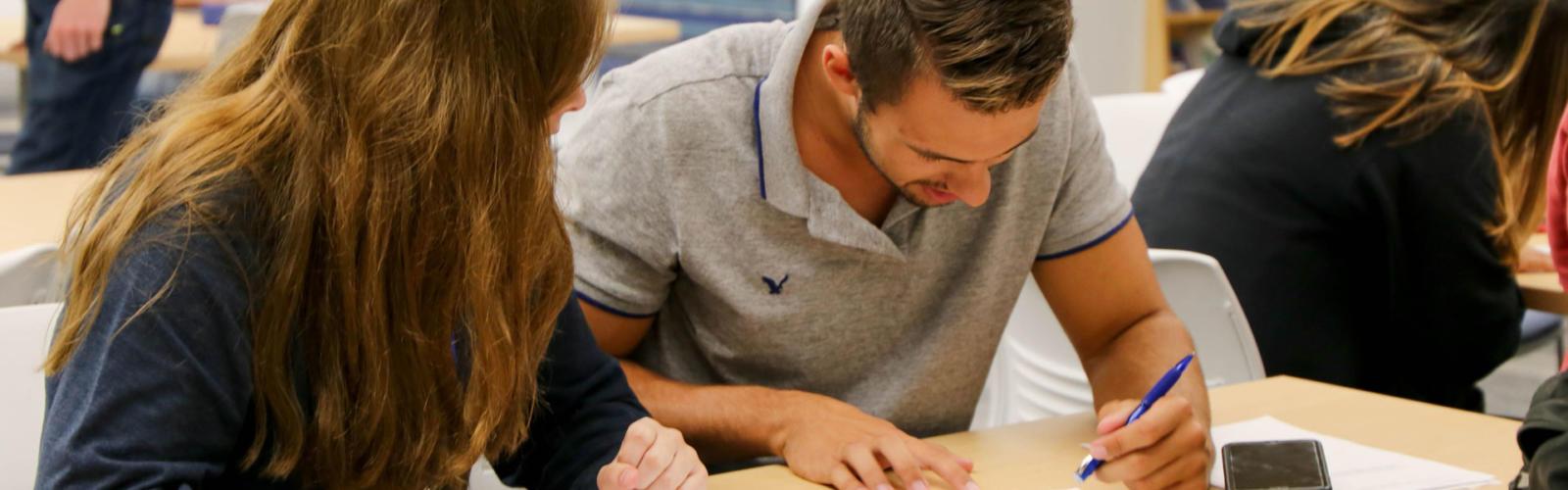 Male and female student working on schoolwork together.